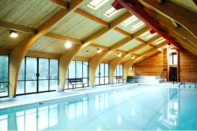 A log swimming pool enclosure provides a wonderful atmosphere