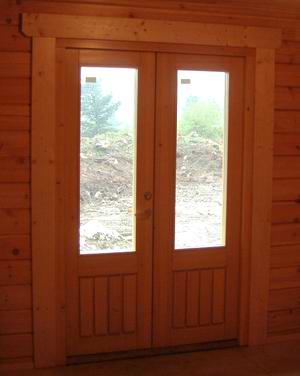 A french style of external timber doors inside a log cabin A french style of external timber doors inside a log cabin
